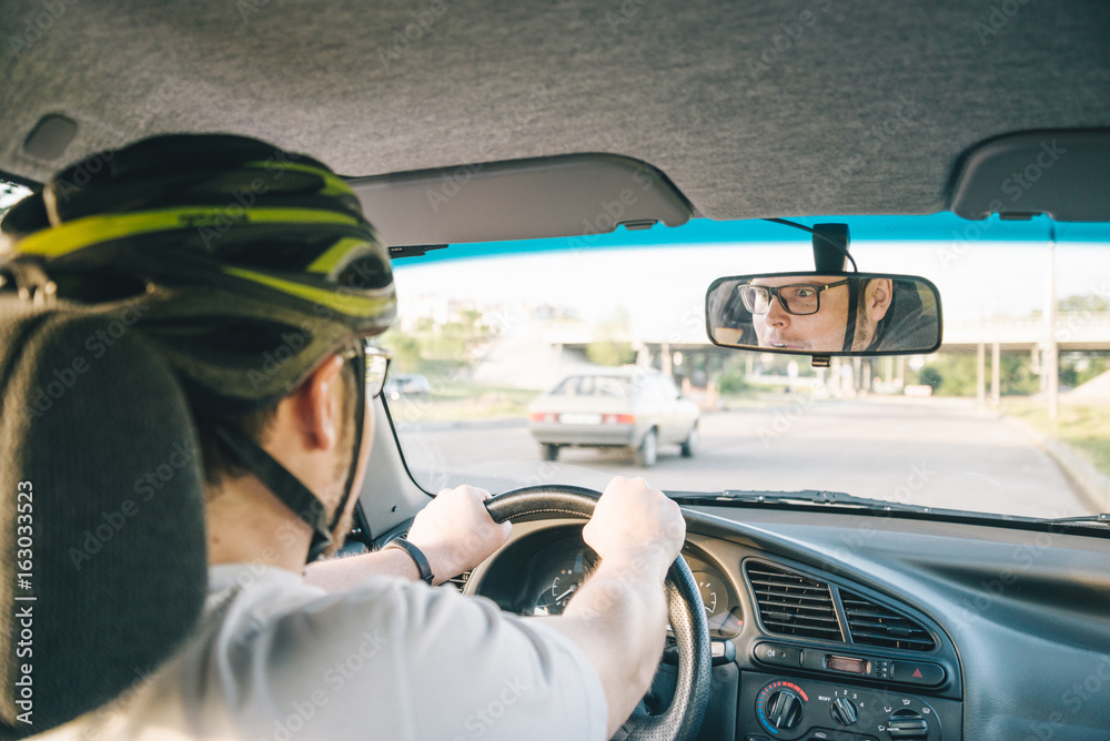 Wall mural man driving car in helmet with horror on her face