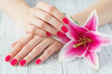 Fotobehang Beautiful woman hands with pink manicure and lily, spa beauty treatment © Zoja