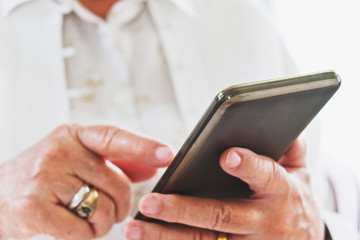 close up image of Senior woman using her mobile phone background.  An idea of modern lifestyle, communication,telecommunication,connectivity, social networking