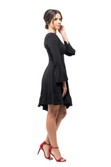 Fototapeta premium Side view of passionate Hispanic dancer relaxing and touching hair looking at camera. Full body length portrait isolated on white background. 