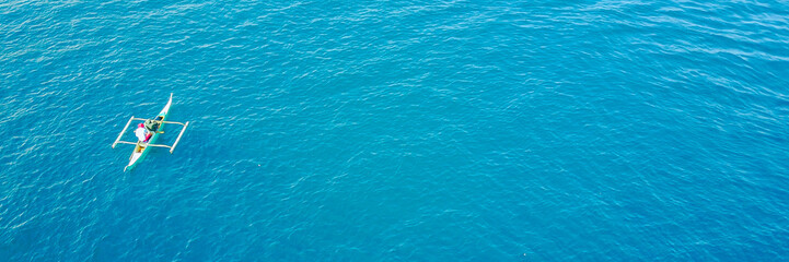 Obraz premium Summer Seascape with Clear Blue Water, Sailing Yacht and Lighthouse on Horizont. Copy Space Background. Toned and Filtered Photo. Panoramic Image Can Be Used as Web Banner or Wide Site Header.