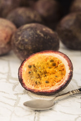 Red passion fruits and slice with  spoon on wood background.