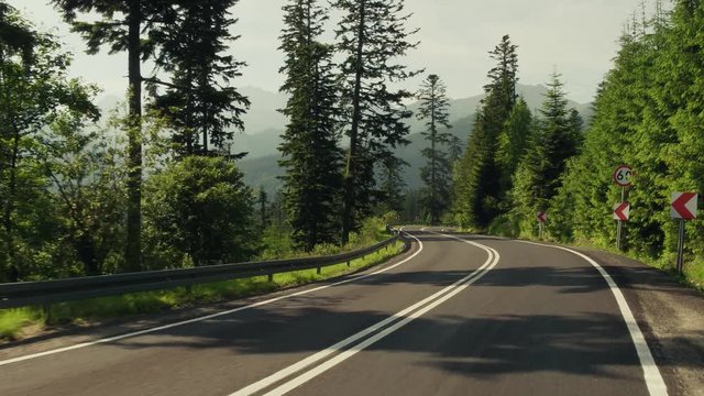 Beautiful Tatra mountains forest curvy car road. 4K gimbal stabilized travelling shot