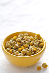 Herbal chamomile tea flowers dried in a green bowl. Chamomile tea ingredients focused
