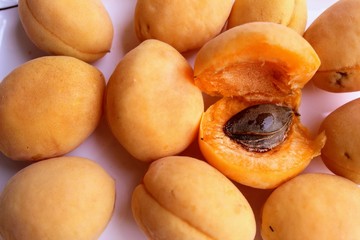 Fresh apricots are a group and individually on the plate and in a human hand.