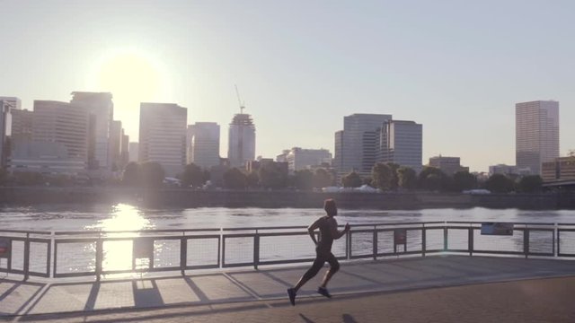 Male Athlete Runs Left To Right, Camera Pans With Him, Shot In Slow Motion