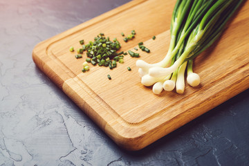 Green onion on the wooden board.