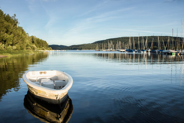 Boote im Seglerhafen am Schluchsee im Hochschwarzwald, Germany vor tiefblauem ruhigen Wasser und...