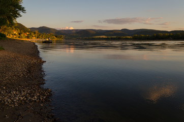 summer beach sunset. beauty sunset by river in summertime. reflection of clouds on water in sunset