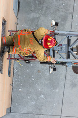 Obraz premium Firefighter training entering and exiting a building on a truck ladder overhead view