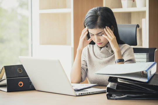 Asian woman working  hard and feeling dizzy at office, woman with office syndrome concept, vintage tone.