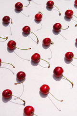 Obraz na płótnie Canvas Close up of red juicy bird-cherries placed diagonally on a white background. Summer fruit and berries