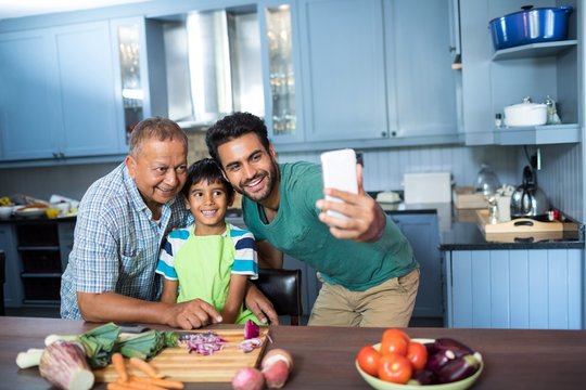 Family taking selfie while preparing food