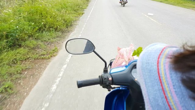 4K POV asian woman riding motorcycle on the street focus on the left hand