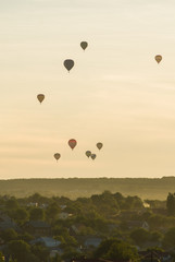 Striped hot air balloon flying over earth, evening landscape and the city with little houses, a river in Laos to Vang Vieng.Laos.