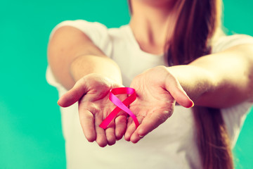 Woman with breast cancer awareness ribbon on hands