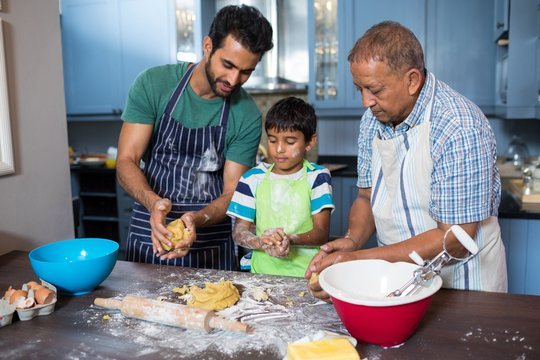 Family holding dough while preparing food