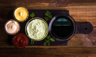 Different sauces on a wooden background