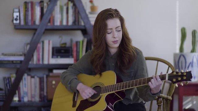Young Woman Plays Guitar In Her Trendy Studio 