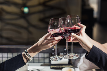 Friends clinking glasses above dinner table