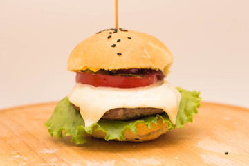 Tasty cheeseburger on a wooden board