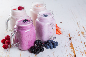 Selection of colorful detox berry drinks on wood background