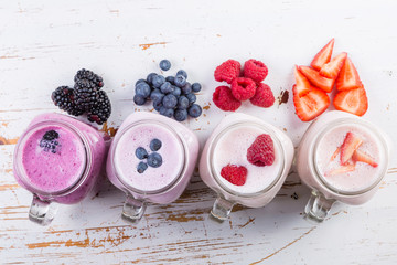 Selection of colorful detox berry drinks on wood background