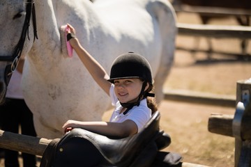 Fototapeta na wymiar Girl grooming the horse in the ranch