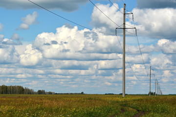 Obraz premium the electricity poles on the field outside of town, under a cloudy sky