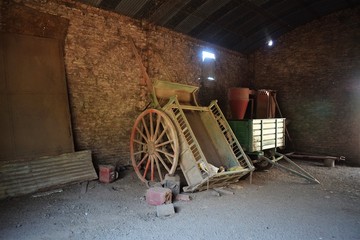 Fototapeta na wymiar An old two wheeled cart inside an old barn 