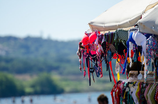 Summer. Peddler Sells Bathing Suits For Woman At The Beach With A Cart