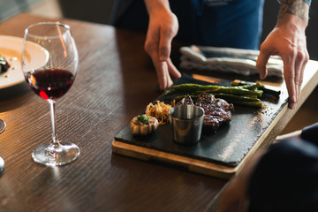 Waiters carrying plates with meat dish at a wedding