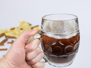 Hand holding mug of beer.