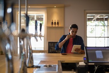 Man using digital tablet while having coffee