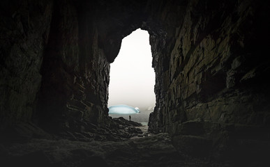The man stands at the end of the cave in the background of the glaciers. Andreev. - 163055987