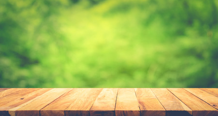 Empty of wood table top on blur of fresh green abstract background .For montage product display or...