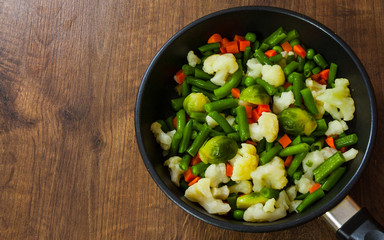 Mixed vegetables in a frying pan. on wood table with copy space. top view