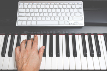 Fototapeta na wymiar male musician hands playing on piano keys, music computer