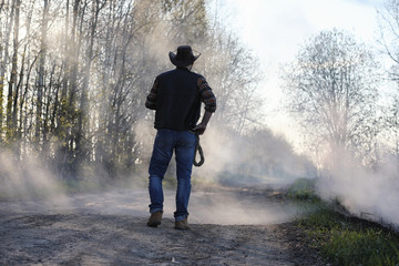 A cowboy in a thick smoke on the road