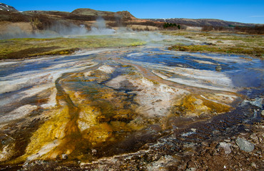 Hot Springs:  Mineral water emerges at near boiling temperatures and flows across colorful mud plains in an area of geothermal activity in southern Iceland.