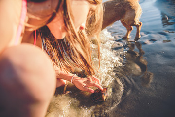Girl with dog playing in shallow water