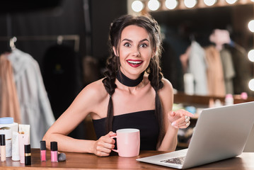 Excited girl using computer in dressing room