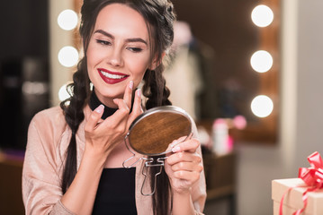 Joyful girl doing make-up backstage