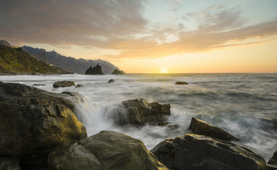Sunset over oceanic, rocky shore
