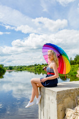 Fototapeta premium Girl sitting with a colorful umbrella