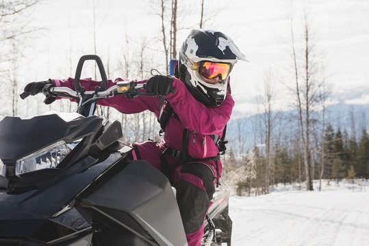Woman relaxing on snowmobile