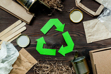 Garbage for recycling with recycling symbol on wooden background top view