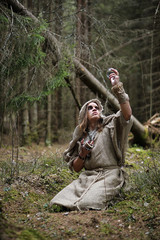 A man in a cassock spends a ritual in a dark forest