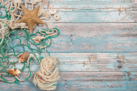 Blue scaffolding wooden marine background with fishing net and seashells
