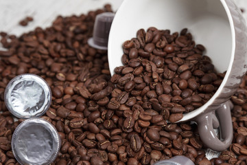 Tazza con chicchi di caffè e capsule 